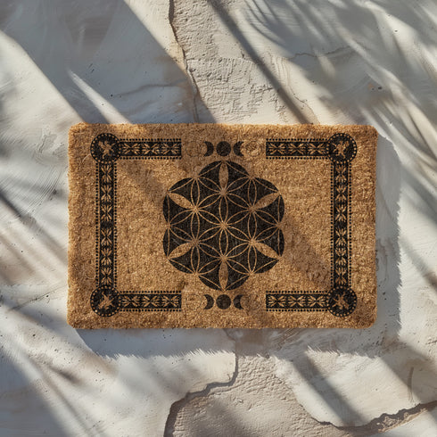 Coir doormat featuring Flower of Life symbol surrounded by lunar phases and protective sigils, in natural tan with black designs.